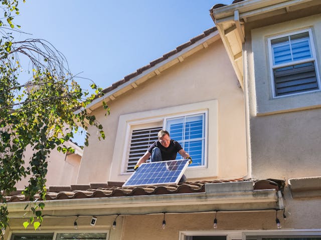 Een man monteert Heliene zonnepanelen op een dak