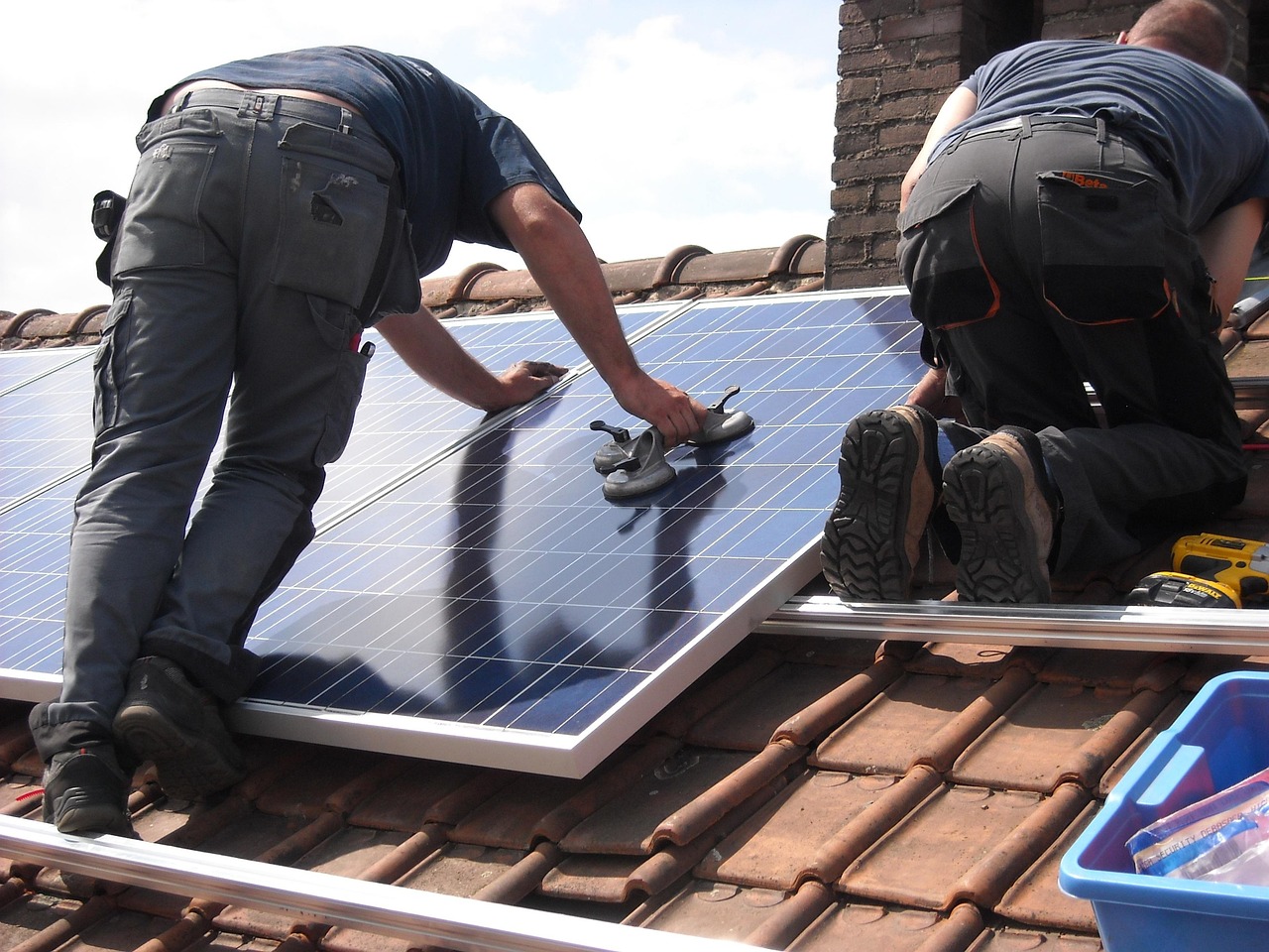 Een technicus installeert Merlin Solar zonnepanelen op een dak